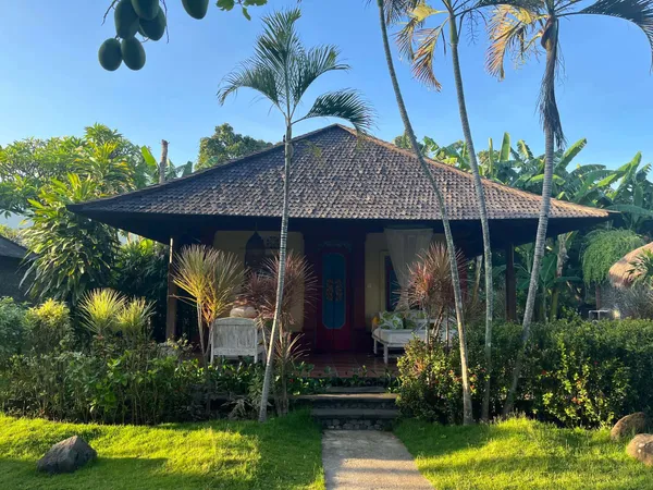 Villa balinaise traditionnelle avec véranda dans un jardin tropical