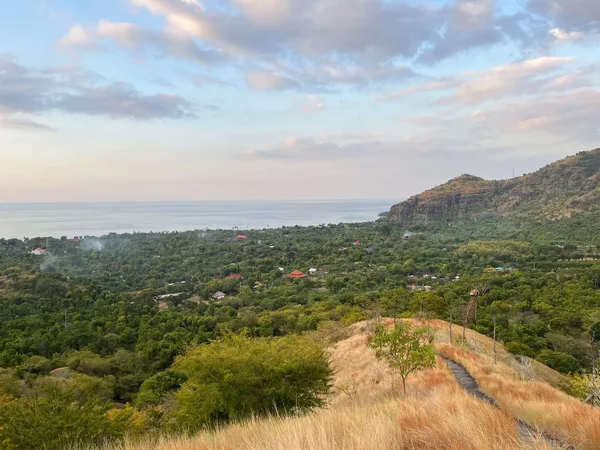 Vue depuis une colline sur un village côtier, la mer et une montagne à Bali